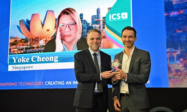 Yoke Cheong of ICS joined online live on the big screen as ICS Chairman and Partner Mathias Posch received the award on her behalf from IAPCO President Ori Lahav. Photo: IAPCO