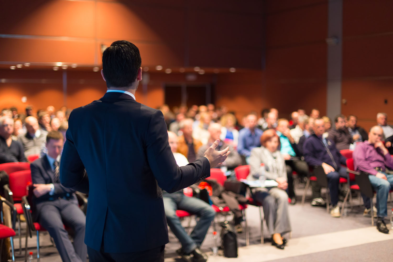Ein Mann spricht auf einer Konferenz zum Publikum.
