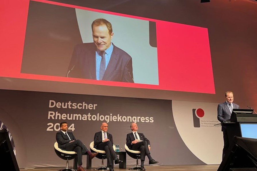 3 Männer auf einer Bühne sitzend