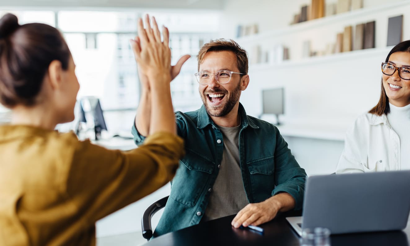 Frau und Mann geben sich High Five in Arbeitsumgebung