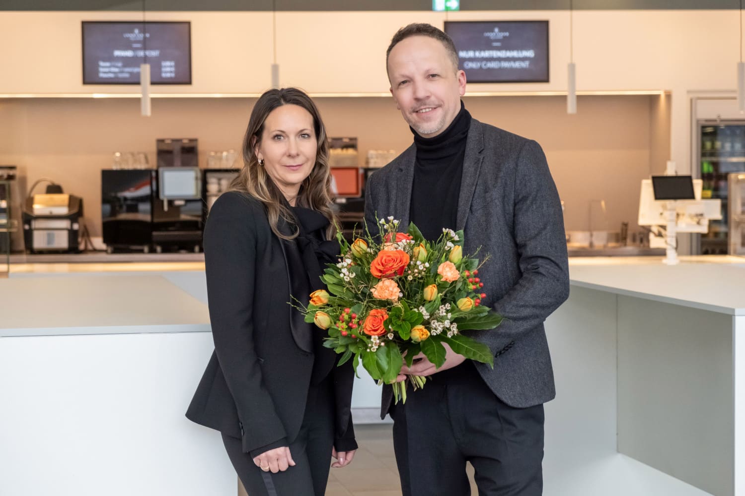Mann übergibt Frau Blumenstrauß bei Verabschiedung