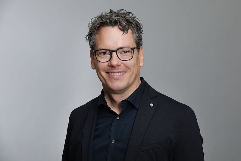 Mann mit Brille im schwarzen Hemd
