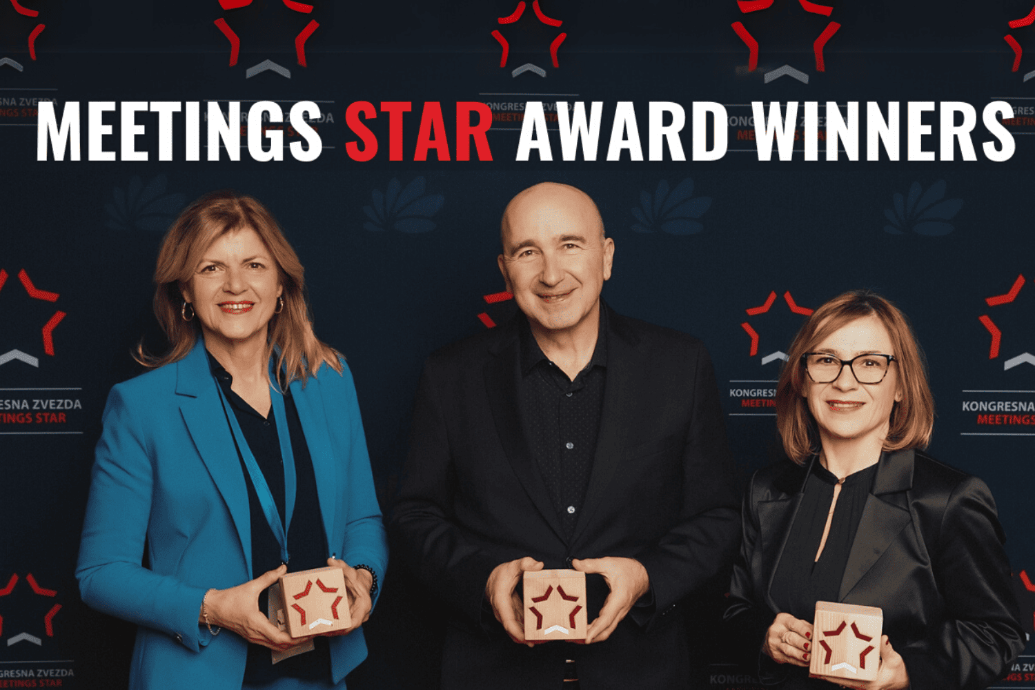 Two women, one man, holding awards