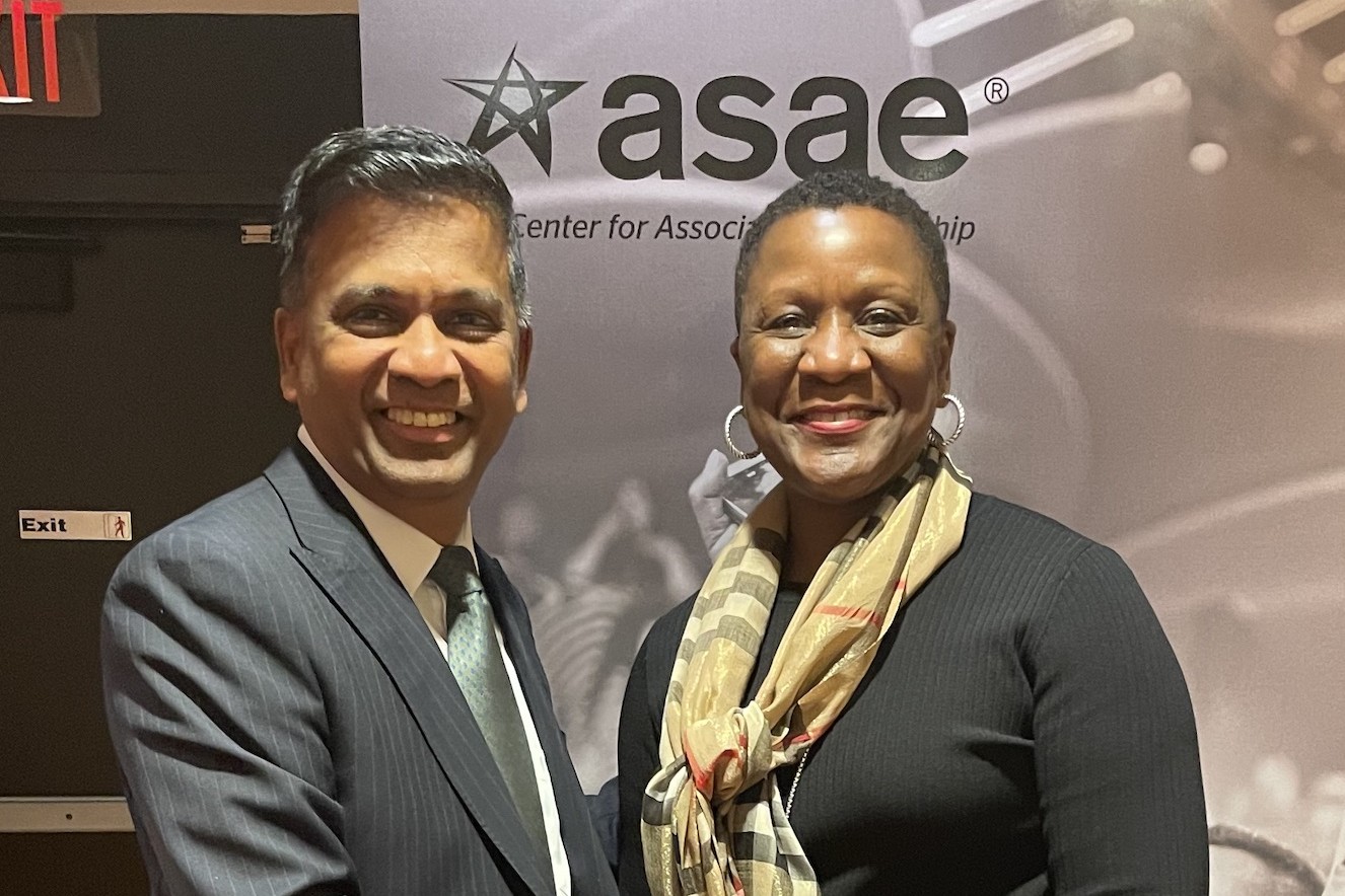 Man and woman in business attire smiling in the camera