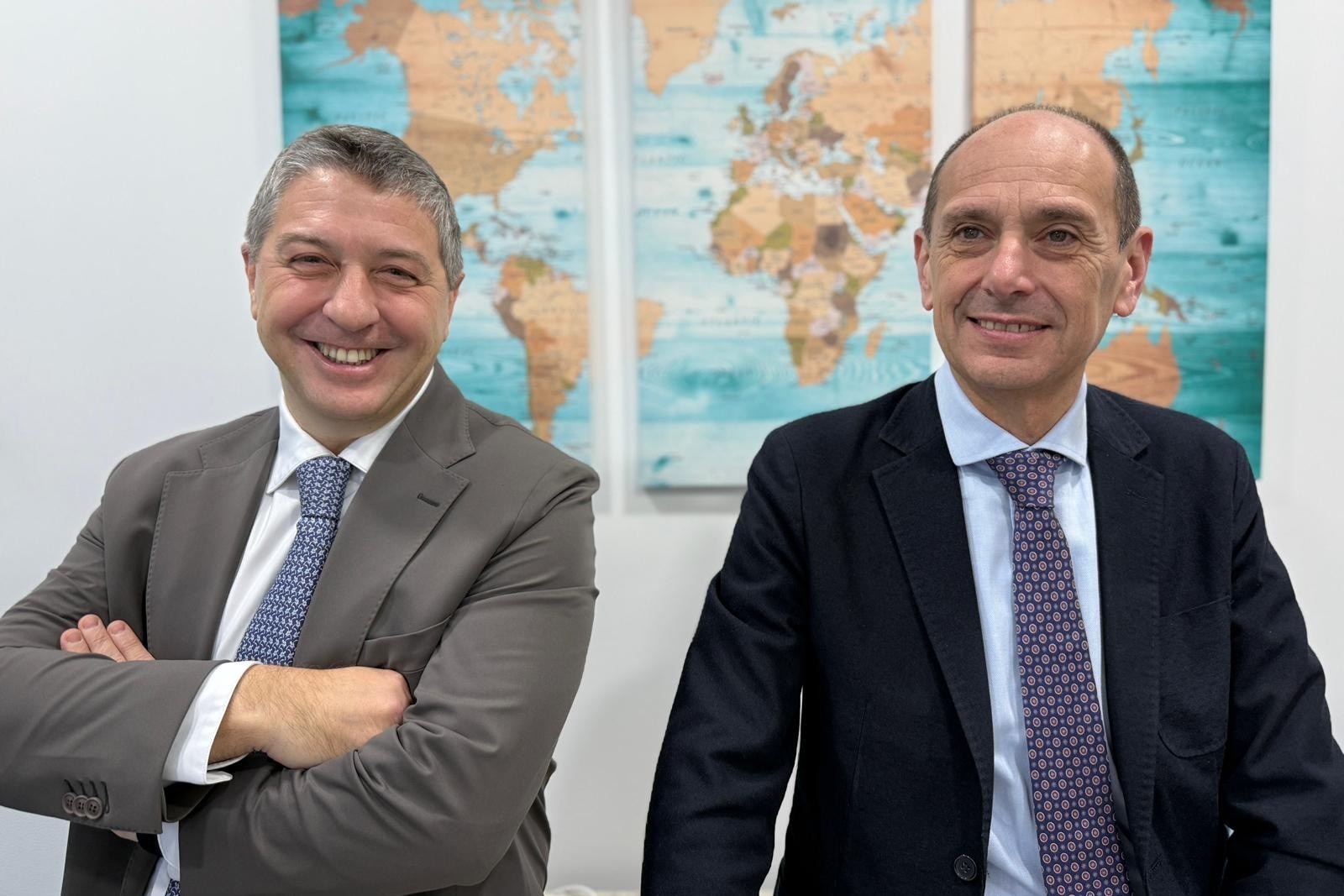 2 men smiling, wearing business attire