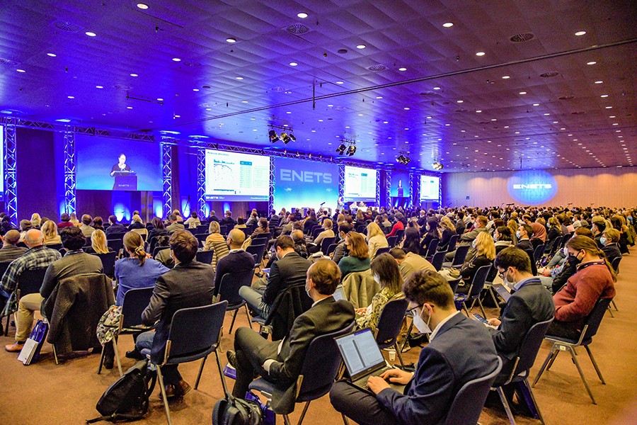 Audience on chairs, stage with speakers