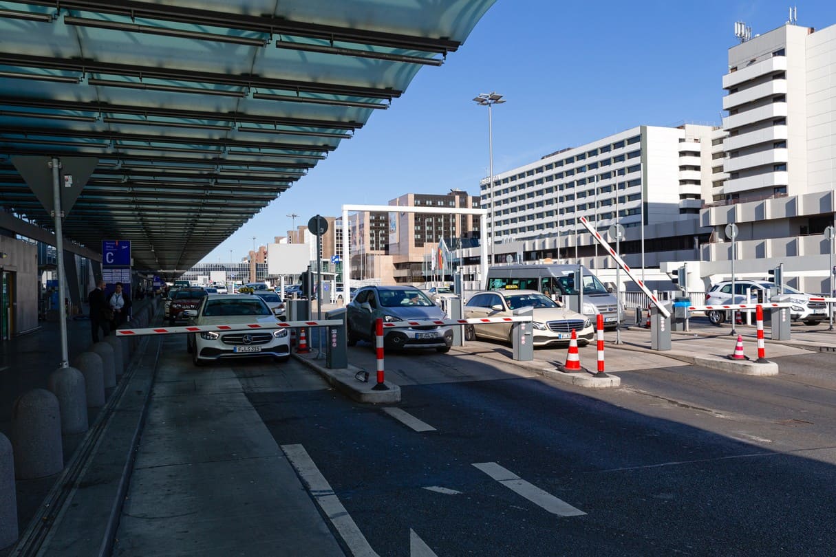 Zufahrt zum Flughafenterminal mit Schranken und Autos