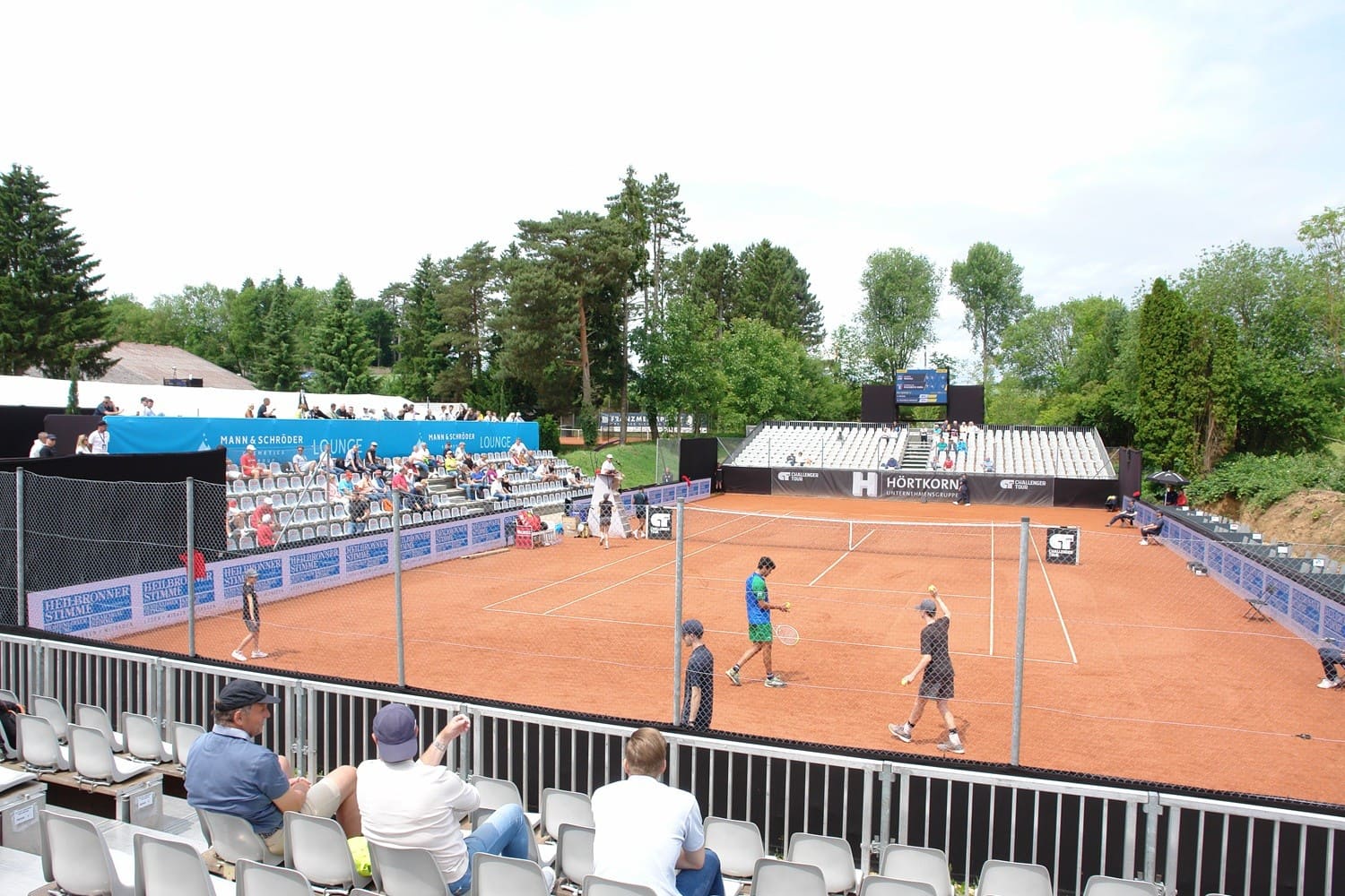 Tennisplatz mit SpielerInnen und ZuschauerInnen