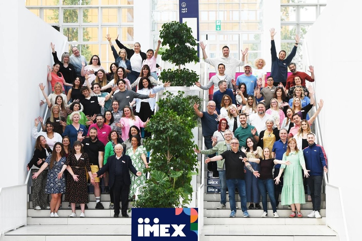 A group of people standing on stairs, cheering for the camera