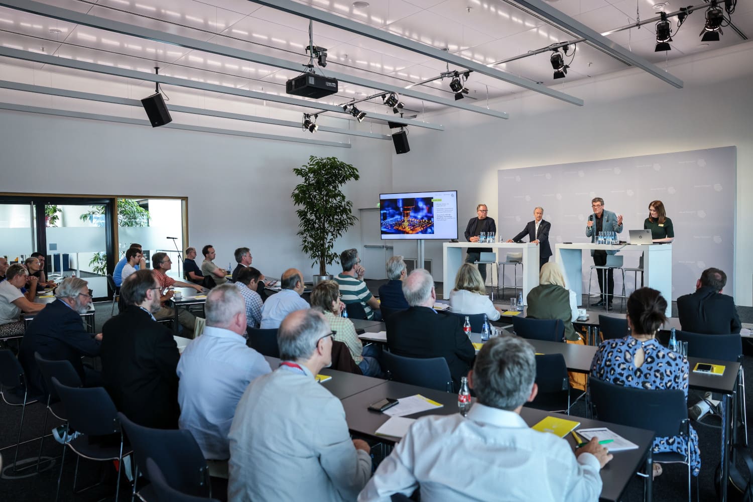 Raum mit Podium und Publikum, Präsentation von Ergebnissen